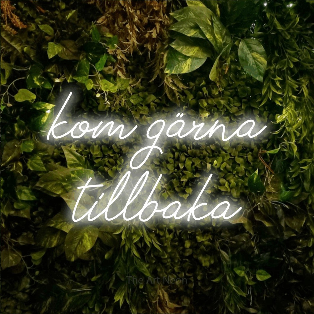 LED neon sign reading “kom gärna tillbaka”, arranged in 2 lines.
