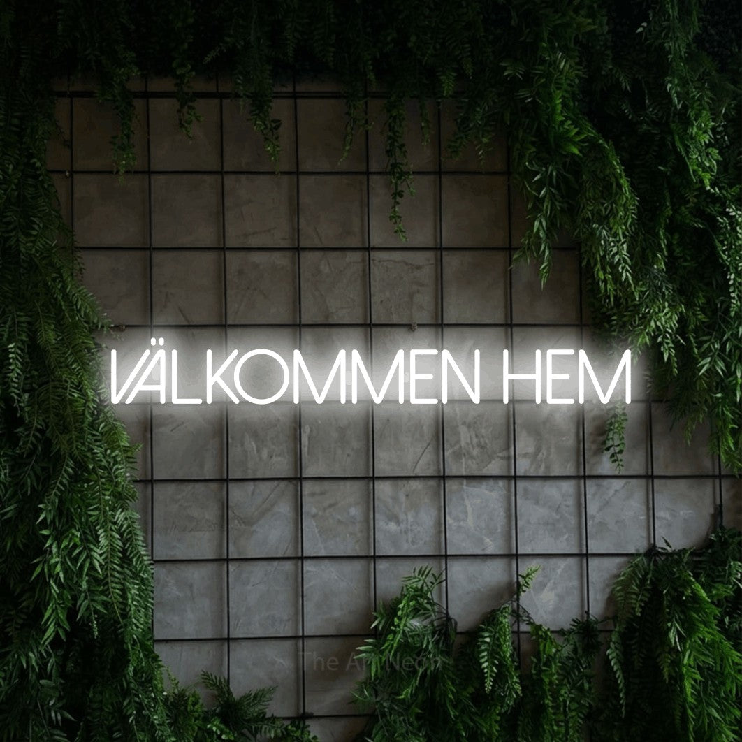 LED neon sign reading “välkommen hem”, arranged in a single line.