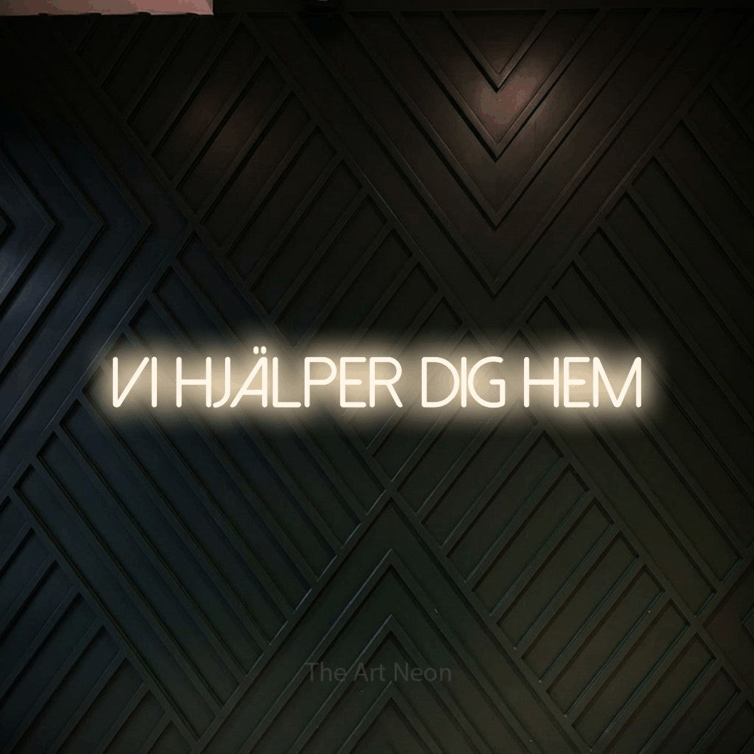 LED neon sign reading “vi hjälper dig hem”, arranged in a single line.