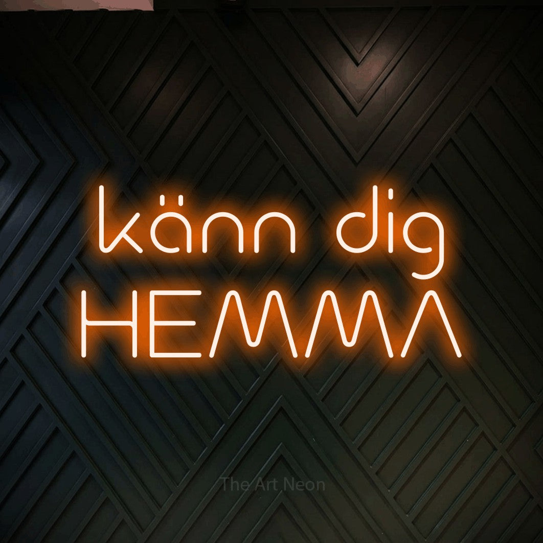 LED neon sign reading “känn dig HEMMA”, arranged in 2 lines.