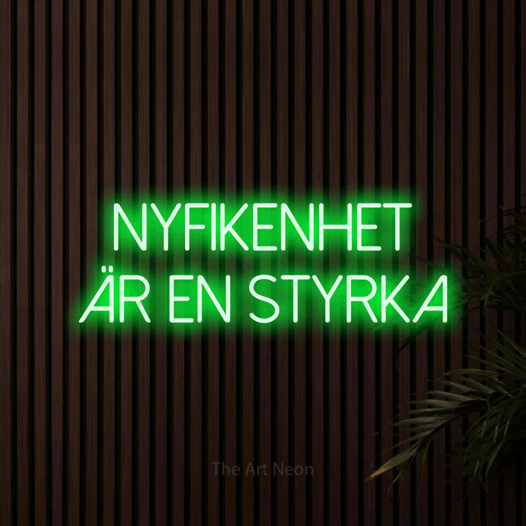 LED neon sign reading “NYFIKENHET ÄR EN STYRKA”, arranged in 2 lines.