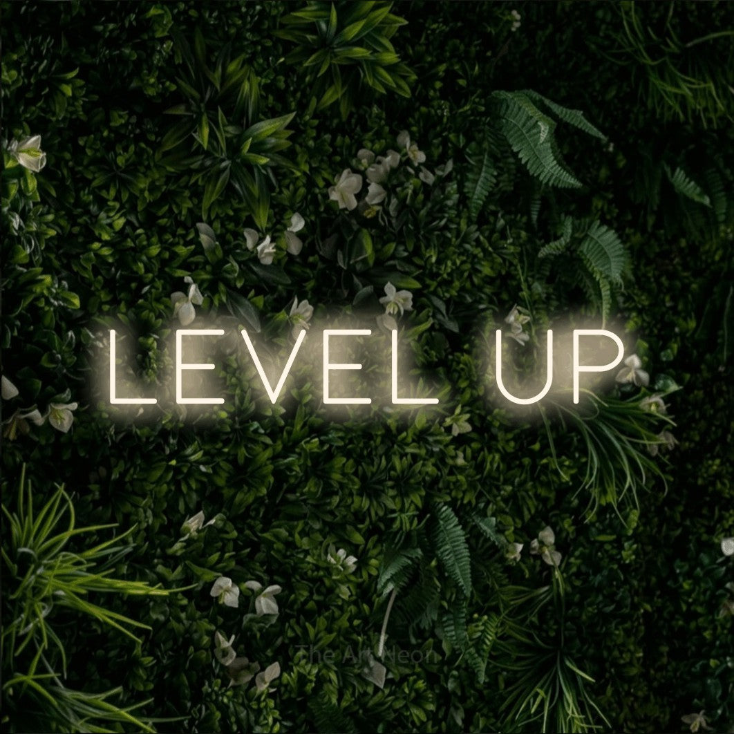 LED neon sign reading “level up”, arranged in a single line.
