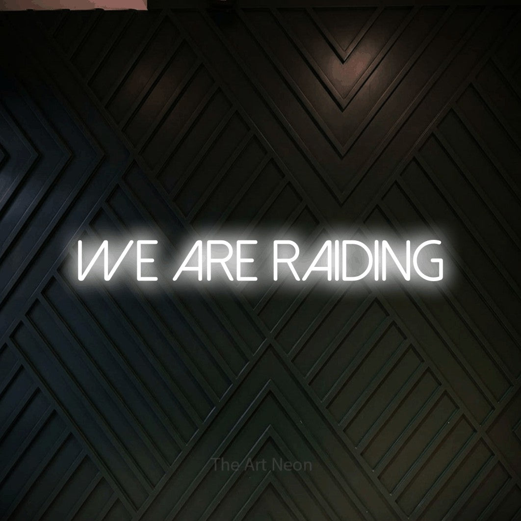 LED neon sign reading “WE ARE RAIDING”, arranged in a single line.