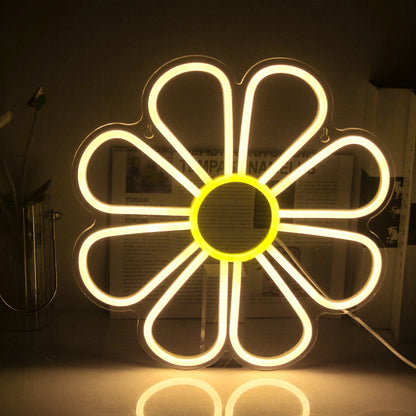 The image displays a vibrant LED neon sign in the shape of a flower.