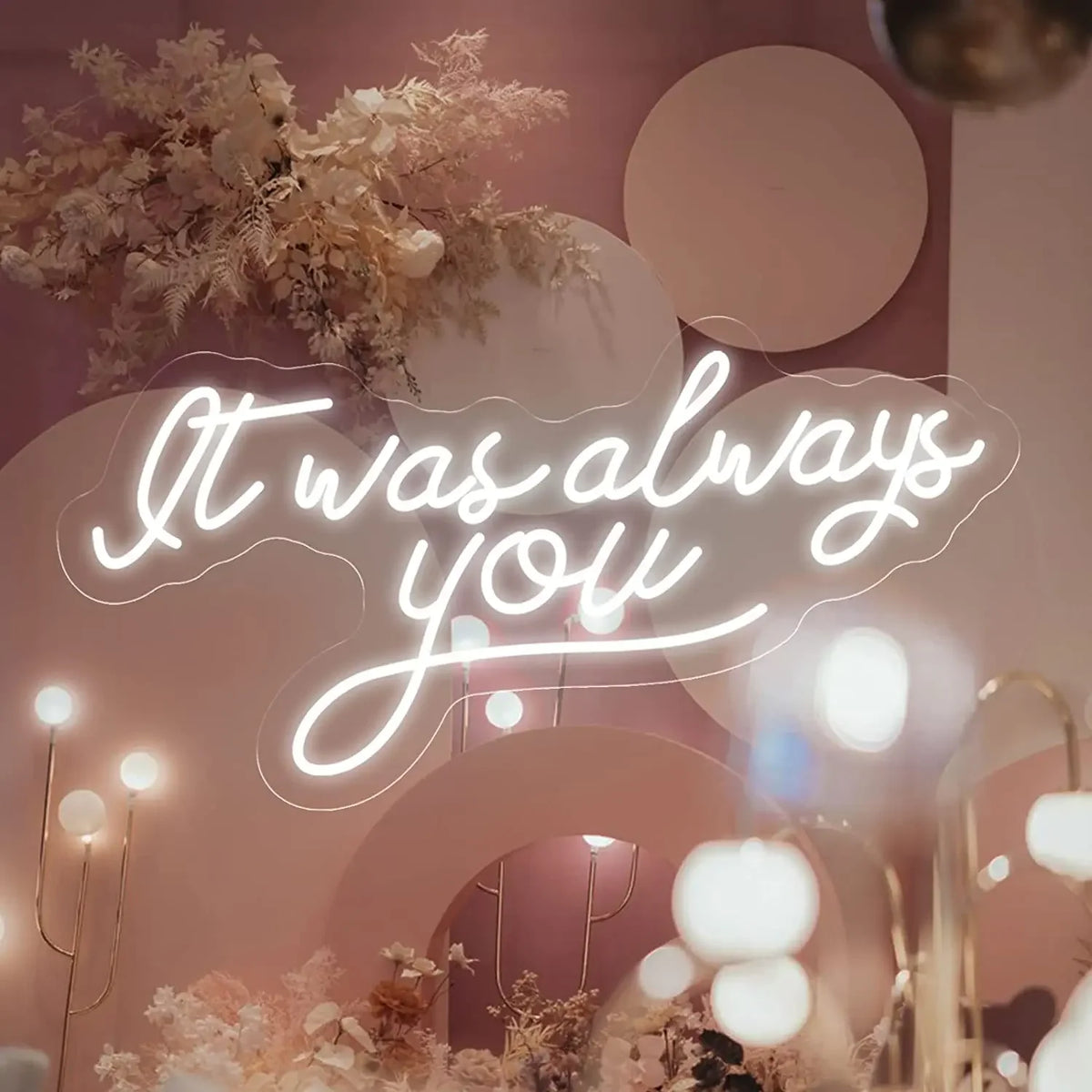 En glödande LED-neonskylt i en varmvit nyans visar frasen "It Was Always You" i kursiv handstil.