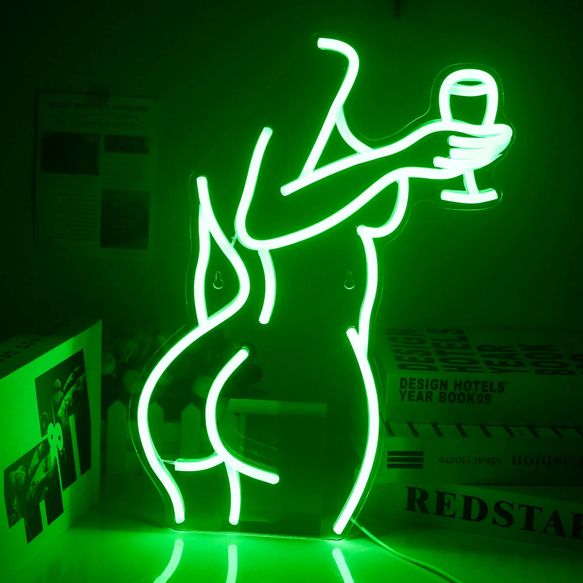 Bilden har en levande LED-neonskylt som visar konturen av en stilfullt klädd kvinna som håller i ett vinglas.