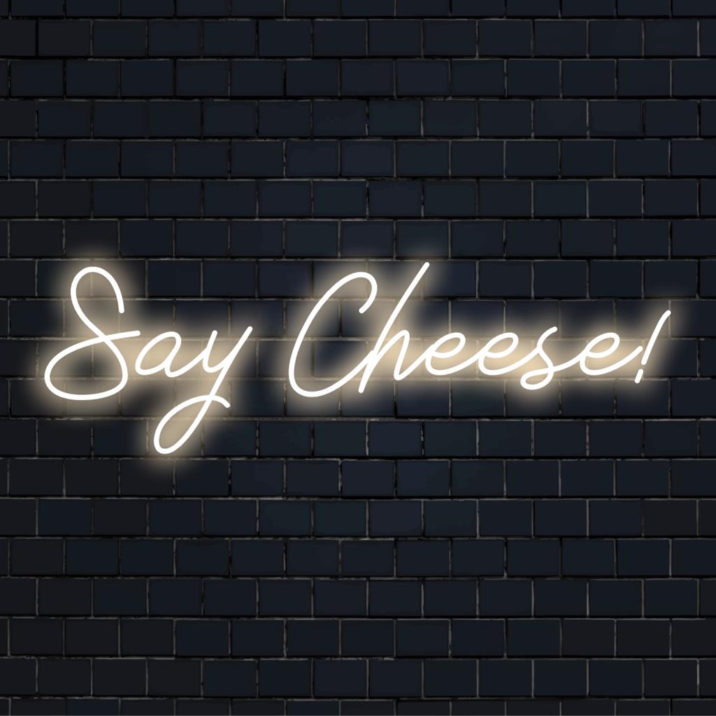 Livlig neonskylt med en lekfull "Say Cheese!" fras; perfekt för att lägga till en anpassad LED-touch till ditt inredningsutrymme.