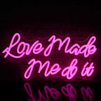 Bilden har en levande LED-neonskylt som visar orden "Love Made Me Do It" i en stilig kursiv stilsort.