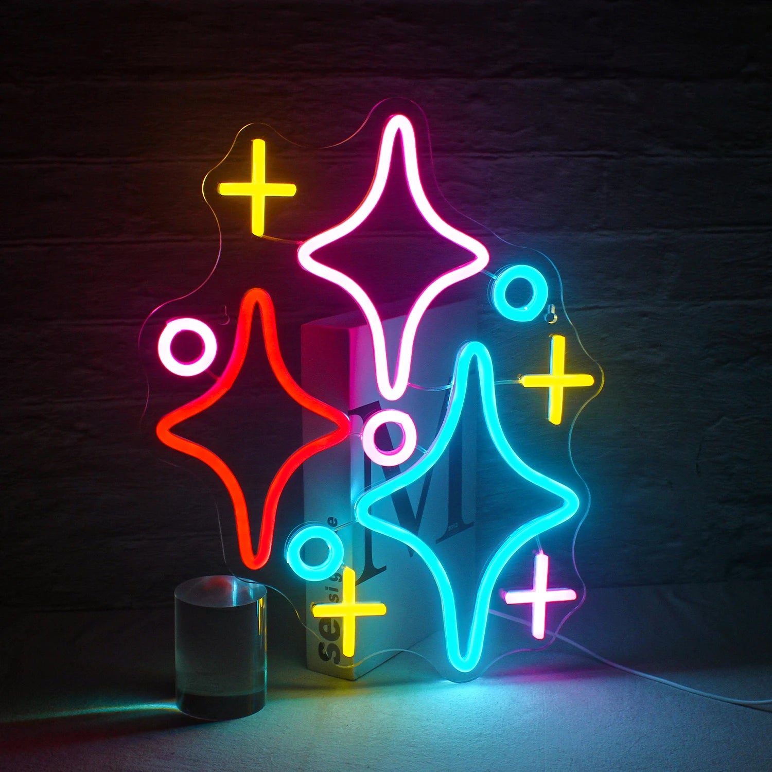 The image features a vibrant LED neon sign in the shape of a cluster of stars.