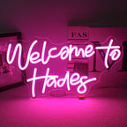 En LED-neonskylt som stavar orden "Welcome to Hades" i ljusa, glödande neonljus.
