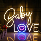 En livlig rosa neonskylt stavar ut orden "Baby Love" i ett lekfullt, kursivt teckensnitt.
