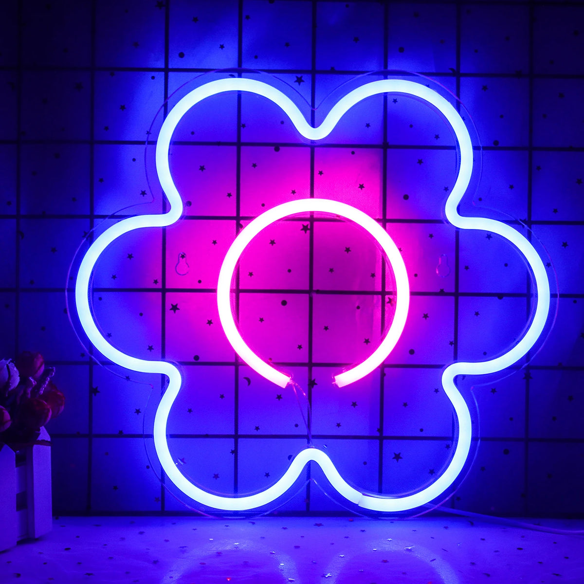 En levande, handgjord LED-neonskylt i form av en blomma visas mot en enkel bakgrund.