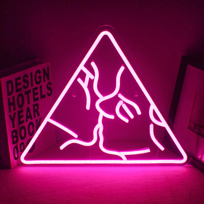A vibrant LED neon sign spelling "Kiss" in a flowing, cursive script.