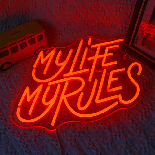 A vibrant LED neon sign displaying the words "My Life My Rules" in a lively cursive font.