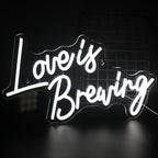 En livlig LED-neonskylt som visar frasen "Love is Breaking", med djärv, modern typografi.