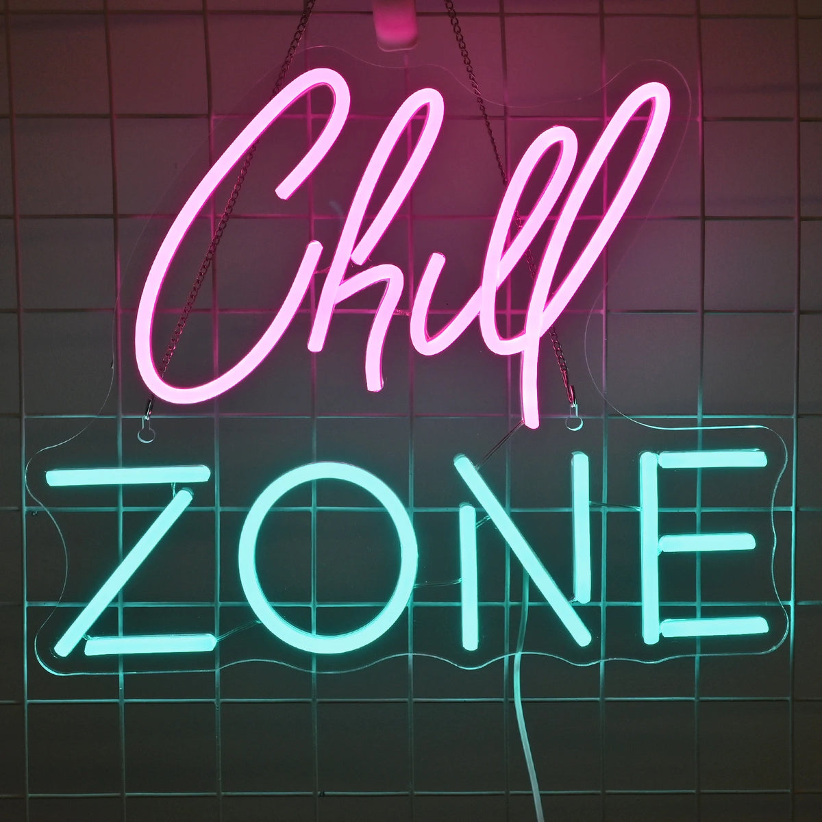 Bilden har en levande LED-neonskylt som visar orden "Chill Zone" i ett elegant, kursivt teckensnitt.
