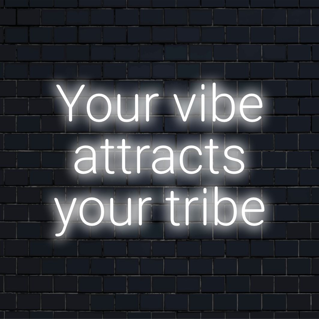 Levande neonskylt läser Your Vibe Atttracts Your Tribe med eleganta LED-bokstäver, perfekt för väggkonst och modern inredning.