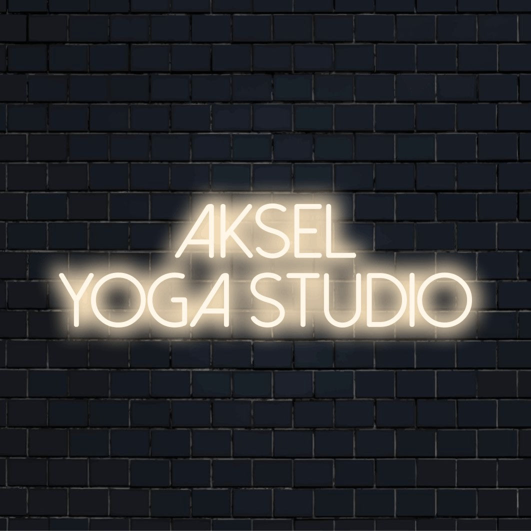 Aksel Yoga Studio Custom Name Neon Sign, bright neon glow against brick backdrop