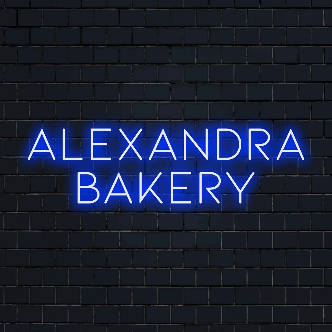 Alexandra Bakery Personalized Neon Light with glowing neon text against black brick wall