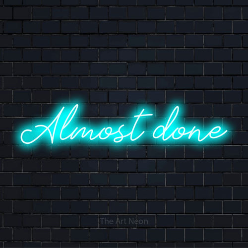 "Almost Done" LED neon sign on a black brick wall
