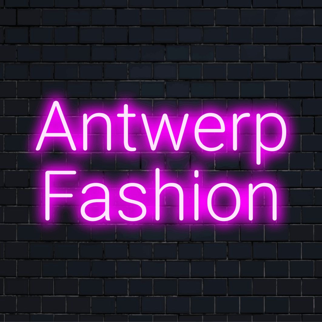 Antwerp Fashion Neon Light with neon text light on dark brick wall