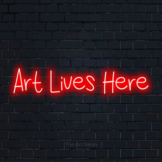 "Art Lives Here" glowing LED neon sign on a black brick wall
