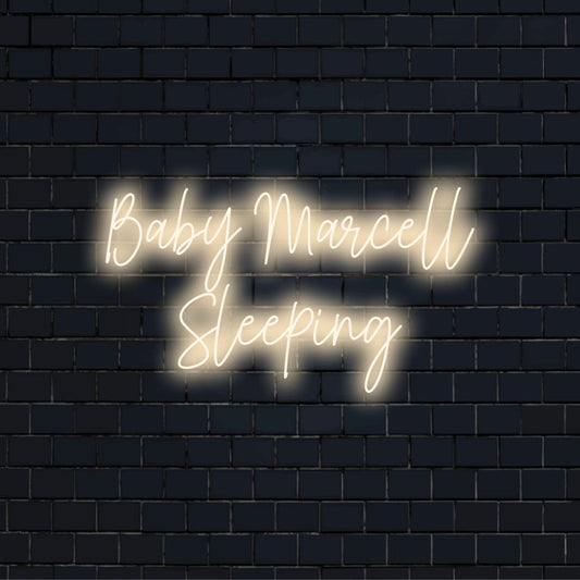 Baby Marcell Sleeping Personalized Neon Light with neon text light against black brick wall