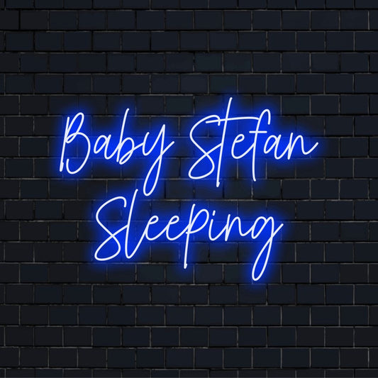 Baby Stefan Sleeping Custom Name Neon Sign, neon text light against black brick wall