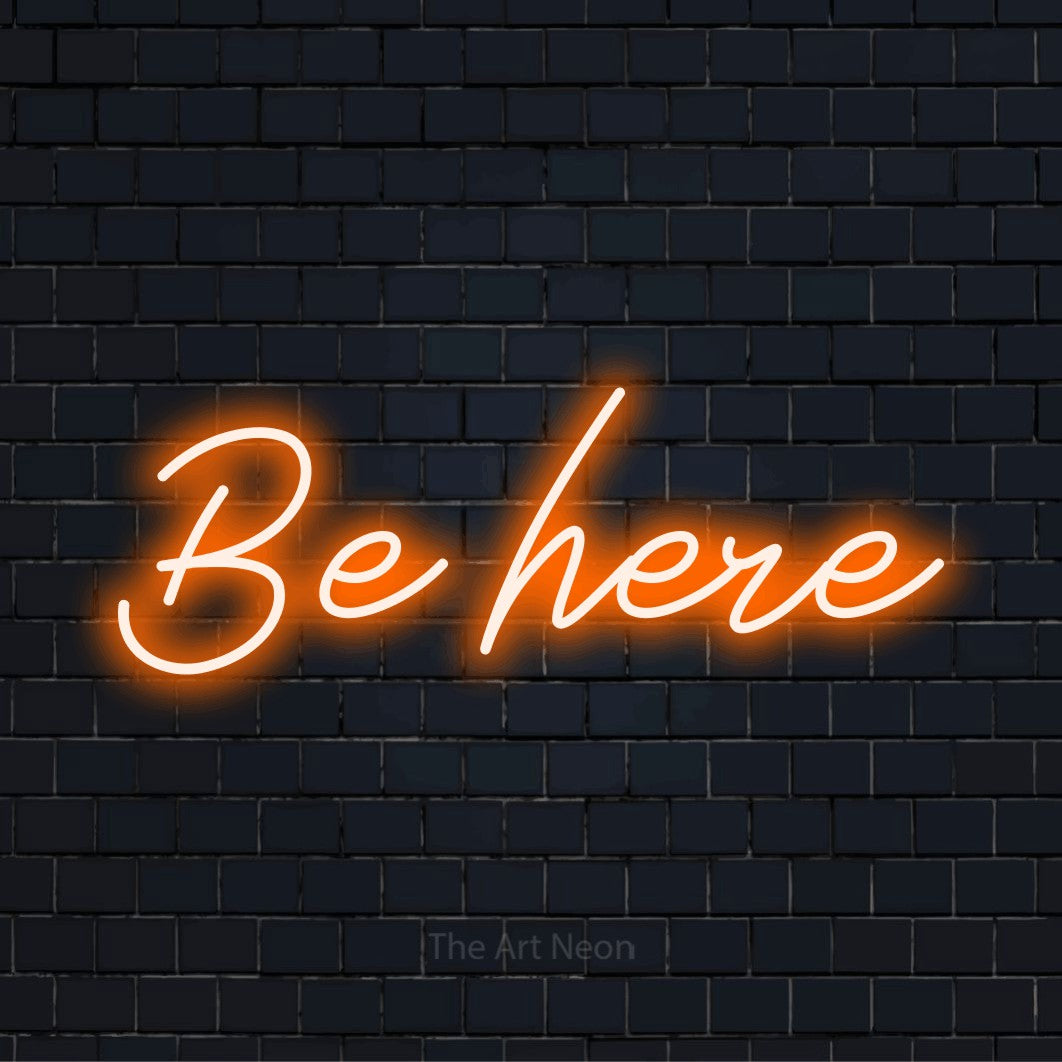 "Be Here" neon text design on a black brick wall