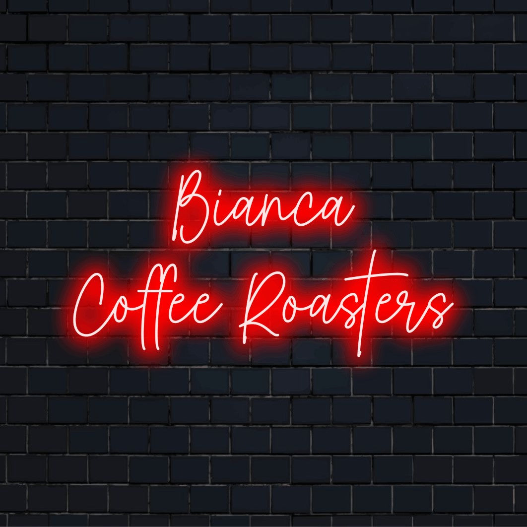Bianca Coffee Roasters Personalized LED Neon Sign, bright neon lettering on dark brick wall