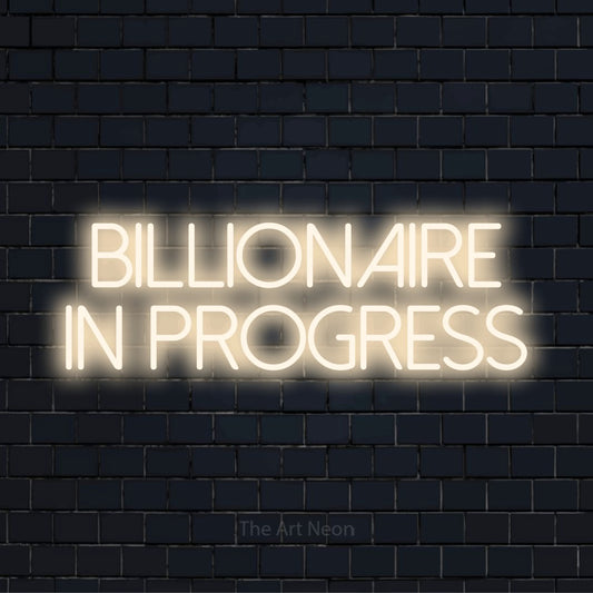 "Billionaire In Progress" glowing LED neon sign on a black brick wall
