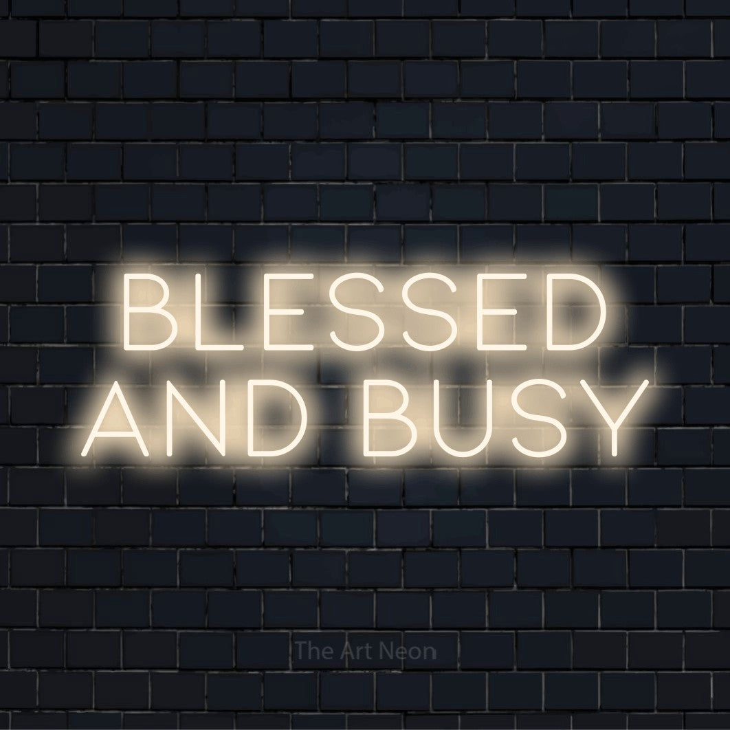 "Blessed And Busy" neon text design on a black brick wall