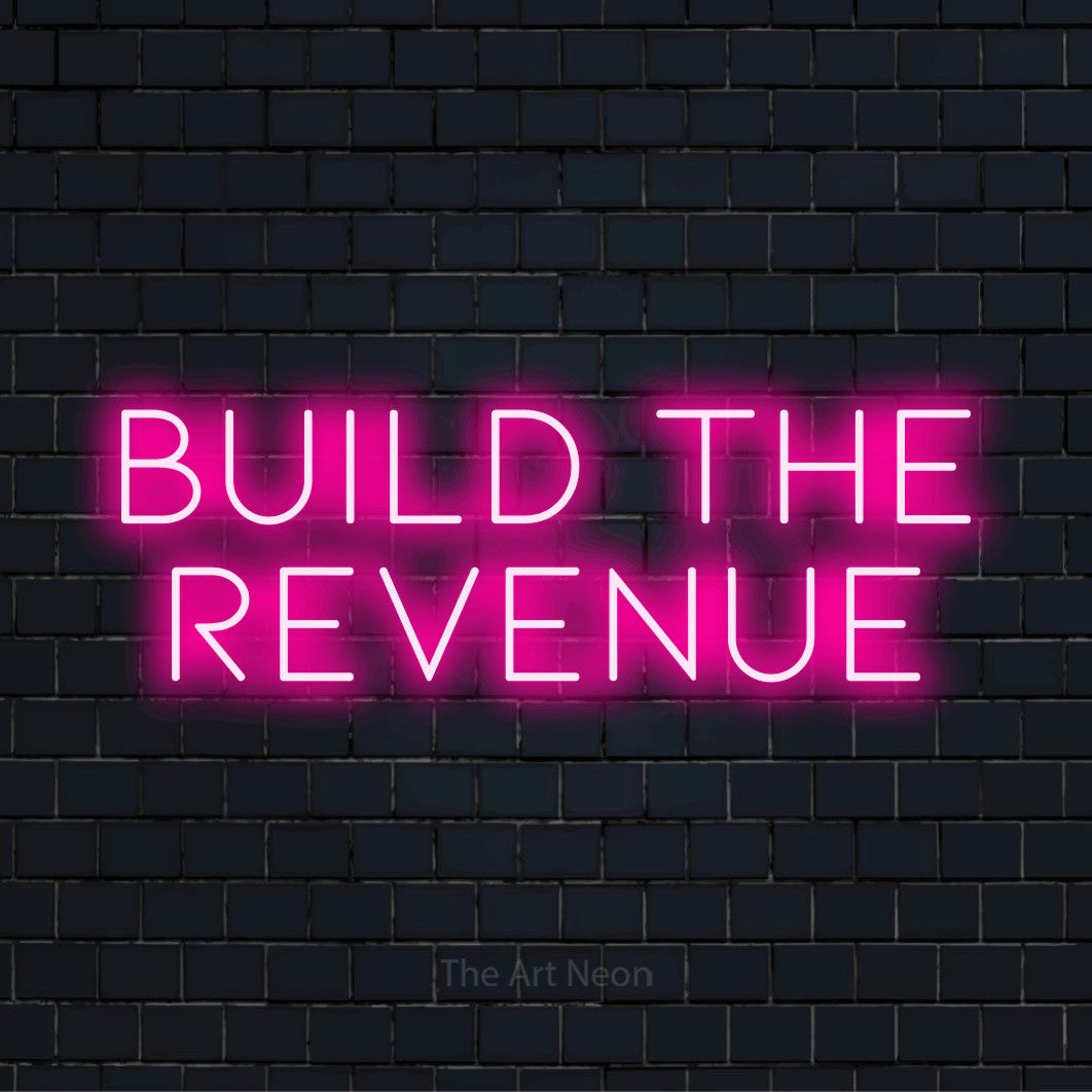 "Build The Revenue" LED neon sign on a black brick wall