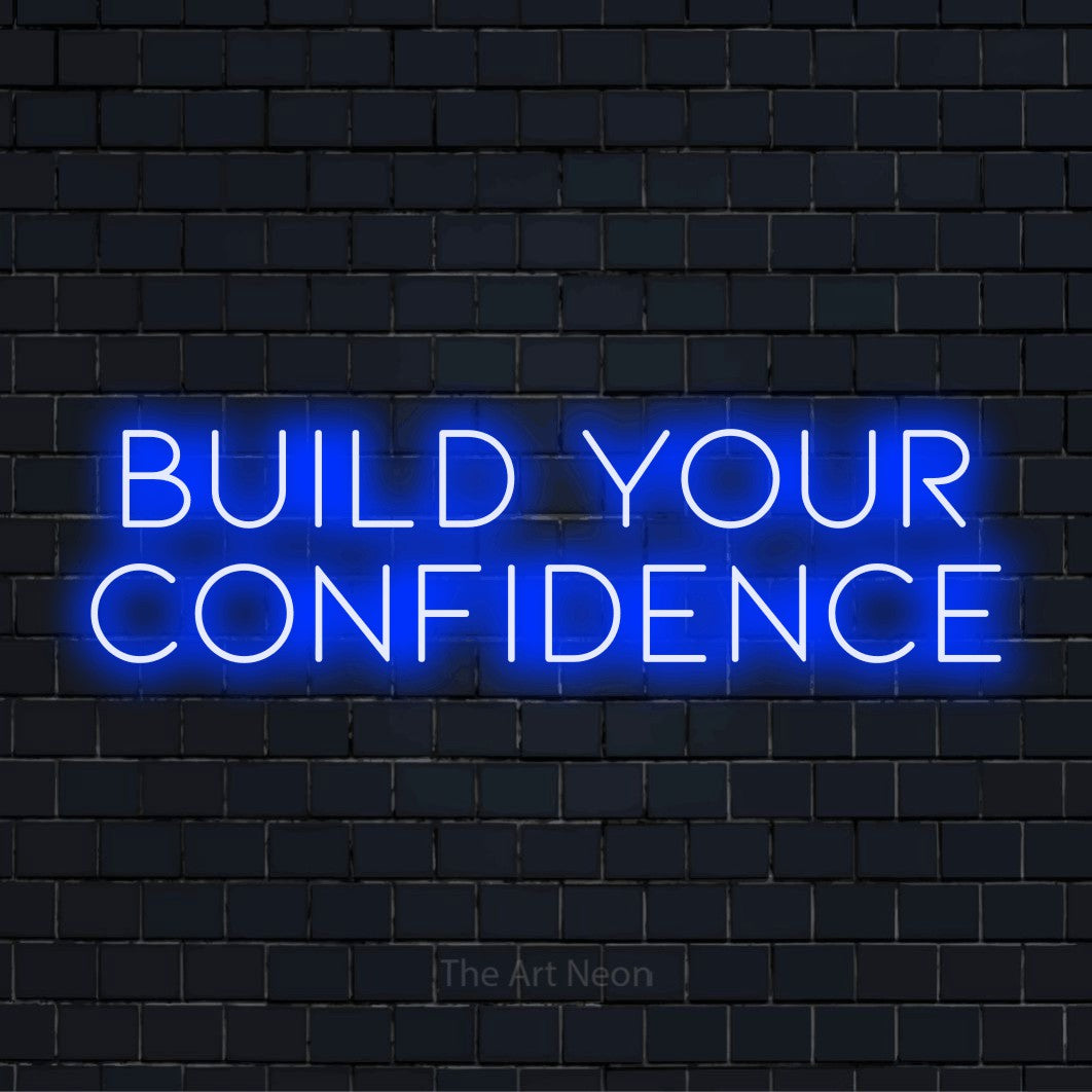 "Build Your Confidence" LED neon sign on a black brick wall