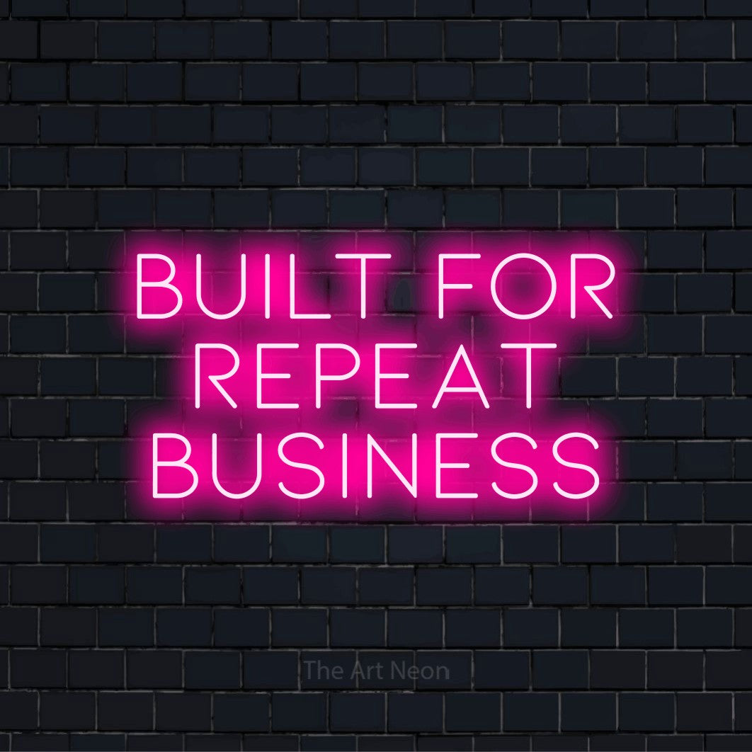 "Built For Repeat Business" LED neon sign on a black brick wall