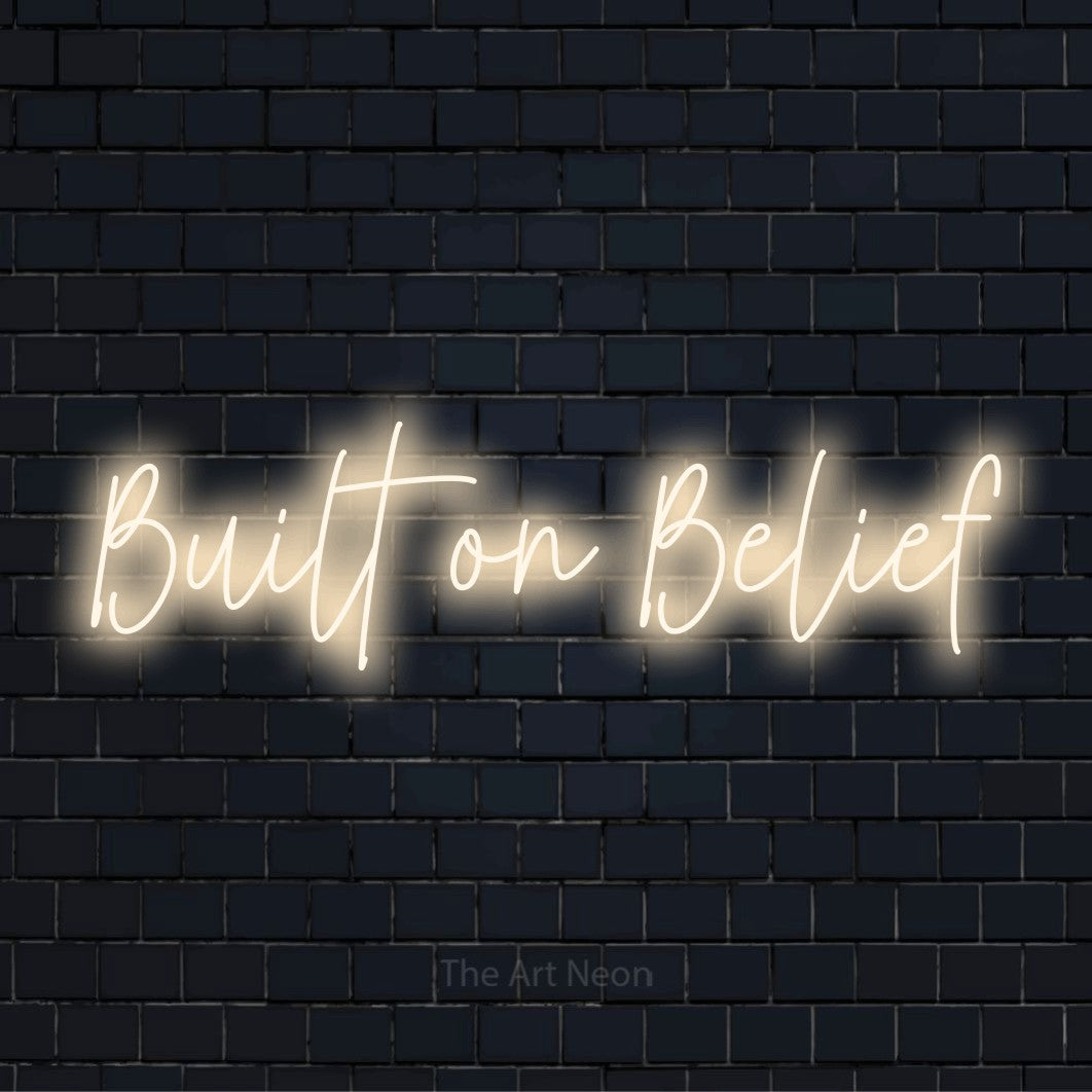 "Built On Belief" LED neon sign on a black brick wall