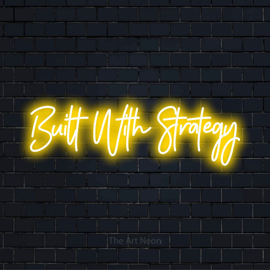 "Built With Strategy" script-style LED neon sign on a black brick wall