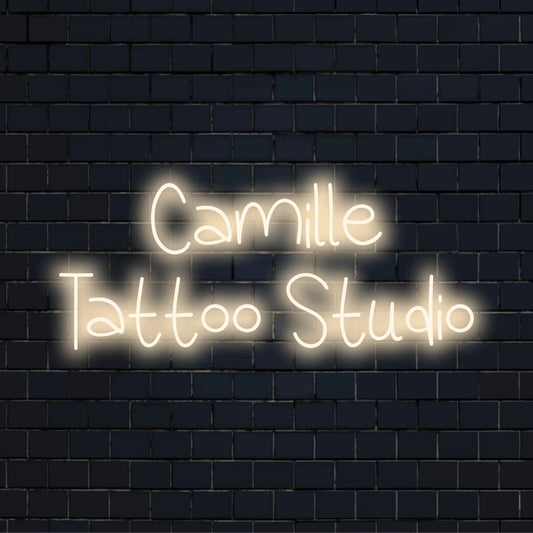 Camille Tattoo Studio Personalized LED Neon Sign, glowing wall decor against brick backdrop