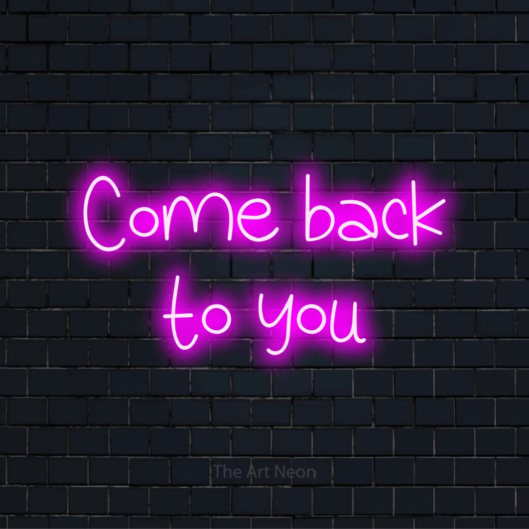 "Come Back To You" LED neon sign on a black brick wall