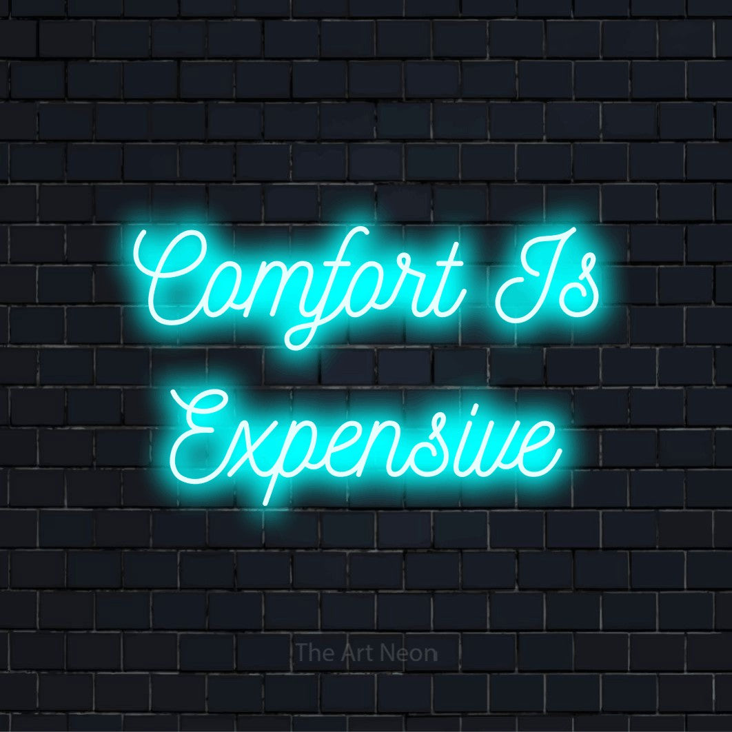 "Comfort Is Expensive" text design with neon effect on a black brick wall