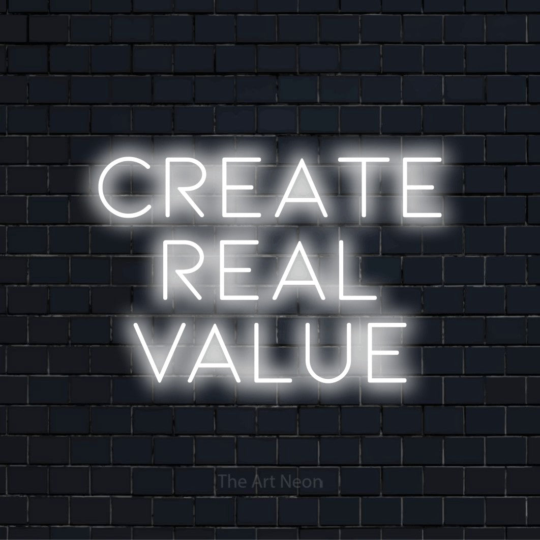 "Create Real Value" glowing LED neon sign on a black brick wall