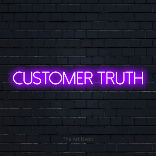 "Customer Truth" script-style LED neon sign on a black brick wall