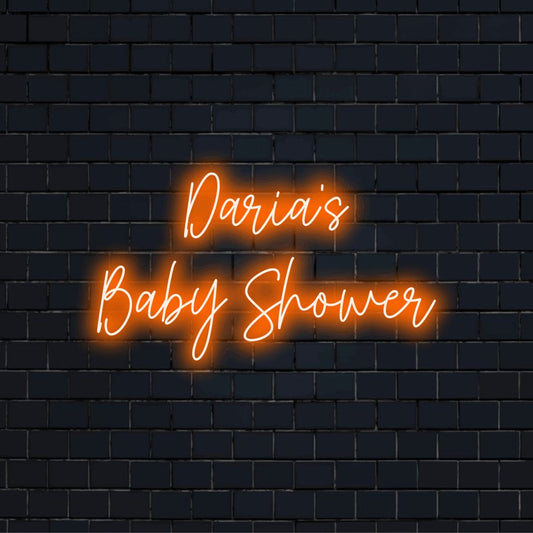 Daria_s Baby Shower Personalized LED Neon Sign, glowing lettering against black brick wall