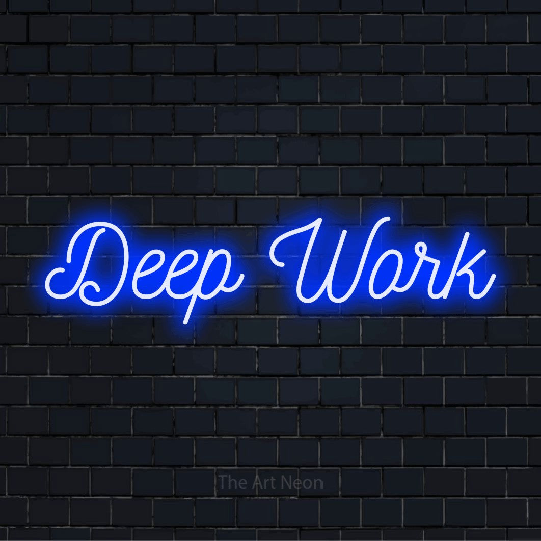 "Deep Work" glowing LED neon sign on a black brick wall