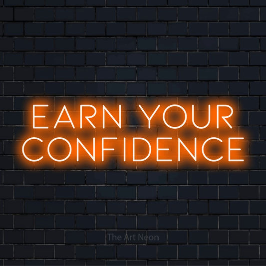 "Earn Your Confidence" text design with neon effect on a black brick wall