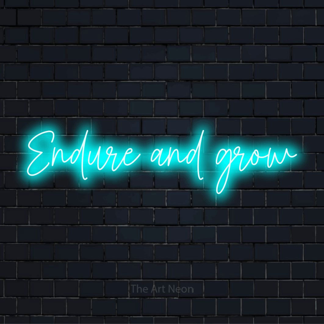 "Endure And Grow" glowing LED neon sign on a black brick wall