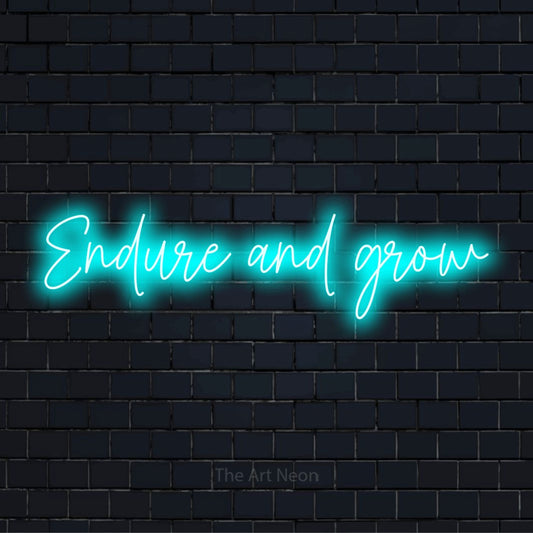 "Endure And Grow" glowing LED neon sign on a black brick wall
