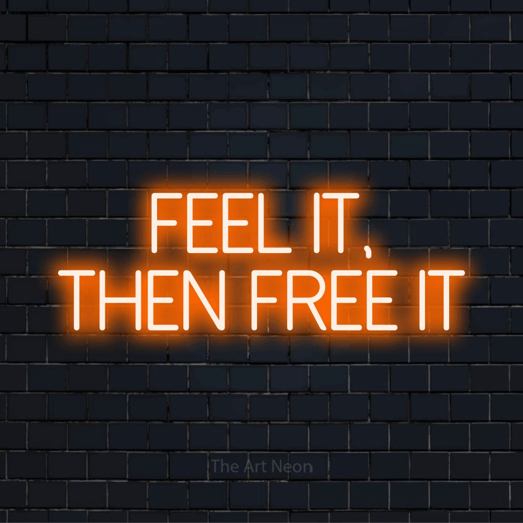 "Feel It, Then Free It" LED neon sign on a black brick wall
