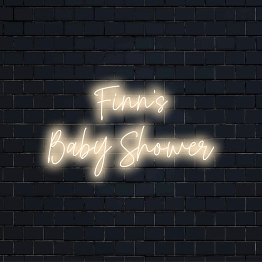 Finn_s Baby Shower Custom Name Neon Sign, glowing neon text on dark brick wall