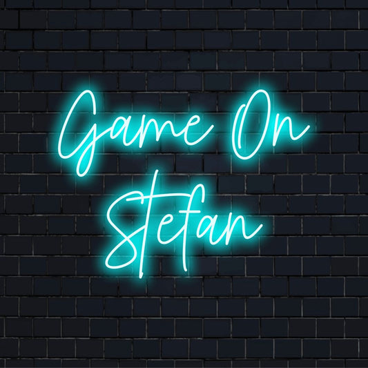 Game On Stefan Custom Name Neon Sign, glowing lettering on dark brick background